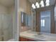 Well-lit bathroom featuring a vanity with white countertops, multiple mirrors, and a glass-enclosed shower at 10829 Ickworth Ct, Las Vegas, NV 89135