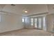 Spacious living room with neutral carpet, shutters and double doors to a covered patio at 10829 Ickworth Ct, Las Vegas, NV 89135