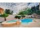 Resort-style backyard with a pool, a spa, and ample space for outdoor entertaining under a Tiki Hut at 10829 Ickworth Ct, Las Vegas, NV 89135