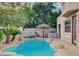 Beautiful swimming pool with lush landscaping and a charming tiki umbrella, perfect for summer at 10829 Ickworth Ct, Las Vegas, NV 89135