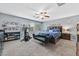 Bright bedroom featuring a ceiling fan, carpeted floors, large windows, and a bed with blue patterned bedding at 11023 Ketchikan St, Las Vegas, NV 89179