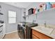 Practical laundry room featuring modern washer and dryer, and storage shelves at 11023 Ketchikan St, Las Vegas, NV 89179