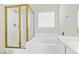 Bright bathroom featuring a soaking tub and a separate shower with gold trim at 11076 Zampino St, Las Vegas, NV 89141