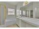 Well-lit bathroom with a double vanity, soaking tub, and separate shower at 11076 Zampino St, Las Vegas, NV 89141