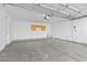 Spacious two-car garage with concrete flooring, overhead lighting, and a wall mounted storage cabinet at 11076 Zampino St, Las Vegas, NV 89141