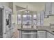 Open kitchen featuring granite countertops, stainless steel appliances, and a bright dining nook at 11076 Zampino St, Las Vegas, NV 89141