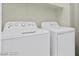A practical laundry room featuring a white washer and dryer set with overhead shelving at 11076 Zampino St, Las Vegas, NV 89141