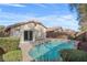 Backyard features a private pool, patio space, a house with a sliding glass door, and green landscaping at 11076 Zampino St, Las Vegas, NV 89141