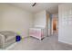 Cozy Bedroom with plush carpet, crib, ceiling fan, chair, and a round blue ottoman at 1172 Strada Pecei, Henderson, NV 89011