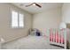 Bright Bedroom featuring plush carpet, ceiling fan, window with shutters, and a white crib at 1172 Strada Pecei, Henderson, NV 89011