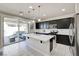 Modern kitchen boasts an island with a sink and black cabinets, open to the patio area at 1172 Strada Pecei, Henderson, NV 89011