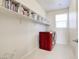Clean laundry room featuring a red washer and dryer set and built-in shelving at 1172 Strada Pecei, Henderson, NV 89011