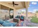 Covered patio with outdoor furniture, ceiling fan, colorful rug and view of the landscaped backyard at 1172 Strada Pecei, Henderson, NV 89011