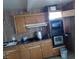 Dated kitchen features wood cabinets, wood wall paneling and basic appliances at 1316 Lawry Ave, Las Vegas, NV 89106