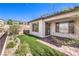 Cozy backyard featuring synthetic grass, landscaping, and a covered patio at 187 Palm Fox Ct, Henderson, NV 89011