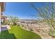 Lush backyard with synthetic grass, manicured landscaping, and a view of the mountains at 187 Palm Fox Ct, Henderson, NV 89011