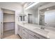 Elegant bathroom boasting a double sink vanity, walk-in shower, and access to a closet at 187 Palm Fox Ct, Henderson, NV 89011