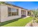 Charming exterior view showcasing manicured landscaping, synthetic grass, and a covered patio at 187 Palm Fox Ct, Henderson, NV 89011