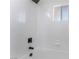 Clean bathroom with white tiled walls, black fixtures, and a window letting in natural light at 2 Utah Way, Henderson, NV 89015