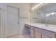 Bright bathroom featuring a vanity with a sink, a large mirror, and a door to a separate toilet or storage area at 2101 High Mesa Dr, Henderson, NV 89012