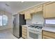 Well-lit kitchen with stainless steel refrigerator, white oven and wood cabinets at 2101 High Mesa Dr, Henderson, NV 89012