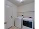 Functional laundry room featuring tile flooring, storage shelf and washer and dryer at 2101 High Mesa Dr, Henderson, NV 89012