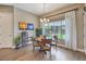 Light-filled dining area with a round wooden table, modern chandelier, and large window at 2509 Chateau Napoleon Dr, Henderson, NV 89044