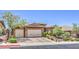 Charming single-story home with a tile roof, stone accents, and a meticulously manicured front yard at 2509 Chateau Napoleon Dr, Henderson, NV 89044