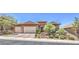 Charming single-story home with a tile roof, stone accents, and a meticulously manicured front yard at 2509 Chateau Napoleon Dr, Henderson, NV 89044