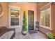 Cozy front porch with a wicker chair and decorative plants, offering a welcoming outdoor space at 2509 Chateau Napoleon Dr, Henderson, NV 89044