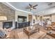 Open-concept living room with stone fireplace, large TV, and open view to the kitchen at 2509 Chateau Napoleon Dr, Henderson, NV 89044