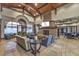 A modern lounge with a fireplace, wood-beam ceiling, and stone flooring at 2509 Chateau Napoleon Dr, Henderson, NV 89044