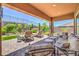 Covered patio area with comfortable seating and lush landscaping, ideal for relaxation and outdoor enjoyment at 2509 Chateau Napoleon Dr, Henderson, NV 89044