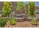 Charming backyard water feature surrounded by lush greenery and desert landscaping, creating a tranquil oasis at 2509 Chateau Napoleon Dr, Henderson, NV 89044