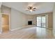 A living room with wood floors, ceiling fan, and fireplace with a sliding glass door to a balcony at 2633 S Durango Dr # 202, Las Vegas, NV 89117