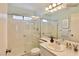 Bright bathroom featuring a tiled shower over tub and vanity with a large mirror and neutral color palette at 2865 Destino Ln, Henderson, NV 89074