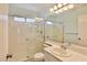 Bright bathroom featuring a tiled shower over tub and vanity with a large mirror and neutral color palette at 2865 Destino Ln, Henderson, NV 89074