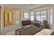 Staged main bedroom featuring sitting area with bay windows, and a peek into the en suite bathroom at 2865 Destino Ln, Henderson, NV 89074