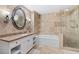 Bathroom with tiled walls, large oval mirror, and walk-in shower at 30 Strada Di Villaggio # 118, Henderson, NV 89011