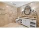 Bathroom with tiled walls, mirror, white cabinets, and toilet at 30 Strada Di Villaggio # 118, Henderson, NV 89011