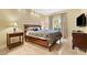 Well-lit bedroom featuring a queen bed with end tables and travertine floors at 30 Strada Di Villaggio # 118, Henderson, NV 89011