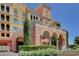 Elegant building exterior with an arched entryway, fountain, colorful facade, and manicured landscaping at 30 Strada Di Villaggio # 118, Henderson, NV 89011