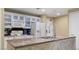 Bright kitchen featuring an island with countertop, white cabinetry, and modern appliances at 30 Strada Di Villaggio # 118, Henderson, NV 89011