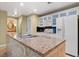 Functional kitchen featuring an island with countertop, white cabinetry, and modern appliances at 30 Strada Di Villaggio # 118, Henderson, NV 89011