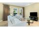 Bright living room with two white sofas, a glass table, and a view of lush greenery at 30 Strada Di Villaggio # 118, Henderson, NV 89011