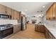 Modern kitchen featuring stainless steel appliances, wood cabinets, and quartz countertops at 307 Balsa St, Henderson, NV 89002