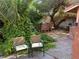 Backyard patio with outdoor seating, an outdoor kitchen, and lush landscaping at 3167 El Cedro Cir, Las Vegas, NV 89121