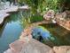 Multi-tiered backyard pond with natural stone accents and lush landscaping at 3167 El Cedro Cir, Las Vegas, NV 89121