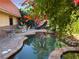 Serene backyard pond surrounded by vibrant flowers and foliage, creating a tranquil and picturesque outdoor oasis at 3167 El Cedro Cir, Las Vegas, NV 89121