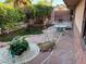 Backyard with mature landscaping, waterfall feature, flagstone patio and elegant seating at 3167 El Cedro Cir, Las Vegas, NV 89121